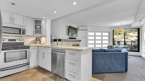 A modern kitchen with white cabinetry, stainless steel appliances, and a large island. - BEST Location! Stunning Mountain Views, Ski-in/Ski-out, Base of both lifts!⛷🚠 (Whistler)