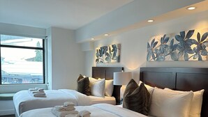 A hotel room with two beds, a large window, and a wall with floral artwork. - BEST Location! Stunning Mountain Views, Ski-in/Ski-out, Base of both lifts!⛷🚠 (Whistler)