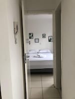 Quarto com cama, porta e parede decorada com quadros.