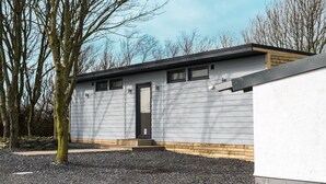 A modern building with a grey exterior, a black door, and a small porch area. - Impeccable 1-bed Bell Tent Near Holyhead (Holyhead)