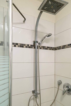 Klassiek appartement | Badkamer | Een regendouche, een haardroger, een bidet, handdoeken