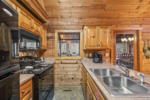 Enjoy cooking in this kitchen with a gas stove, stainless steel sink, and ample natural light.