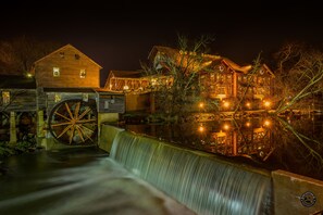 Experience the charm of a historic water mill, situated beside a serene waterway, with a traditional design that offers a rustic atmosphere.