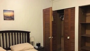 A hotel room with a bed, a nightstand, a lamp, a painting on the wall, and a wardrobe. - 3 BR/ 2 full baths unit with south shore view. (Christiansted)