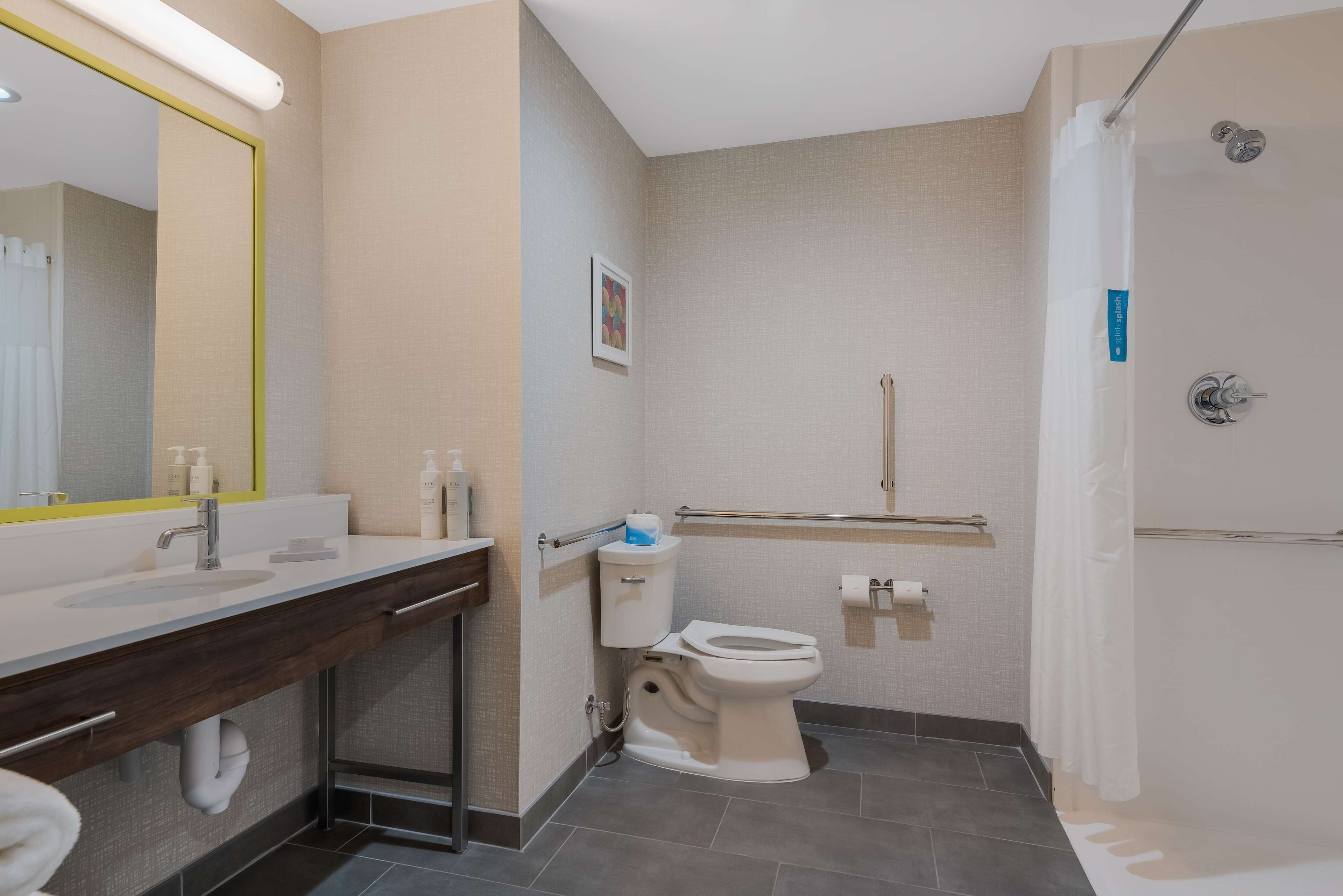 A modern bathroom with a sink, toilet, and shower.