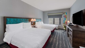 A hotel room with two beds, a desk with a TV, and a window with blinds. - Hampton Inn Williams (Williams)