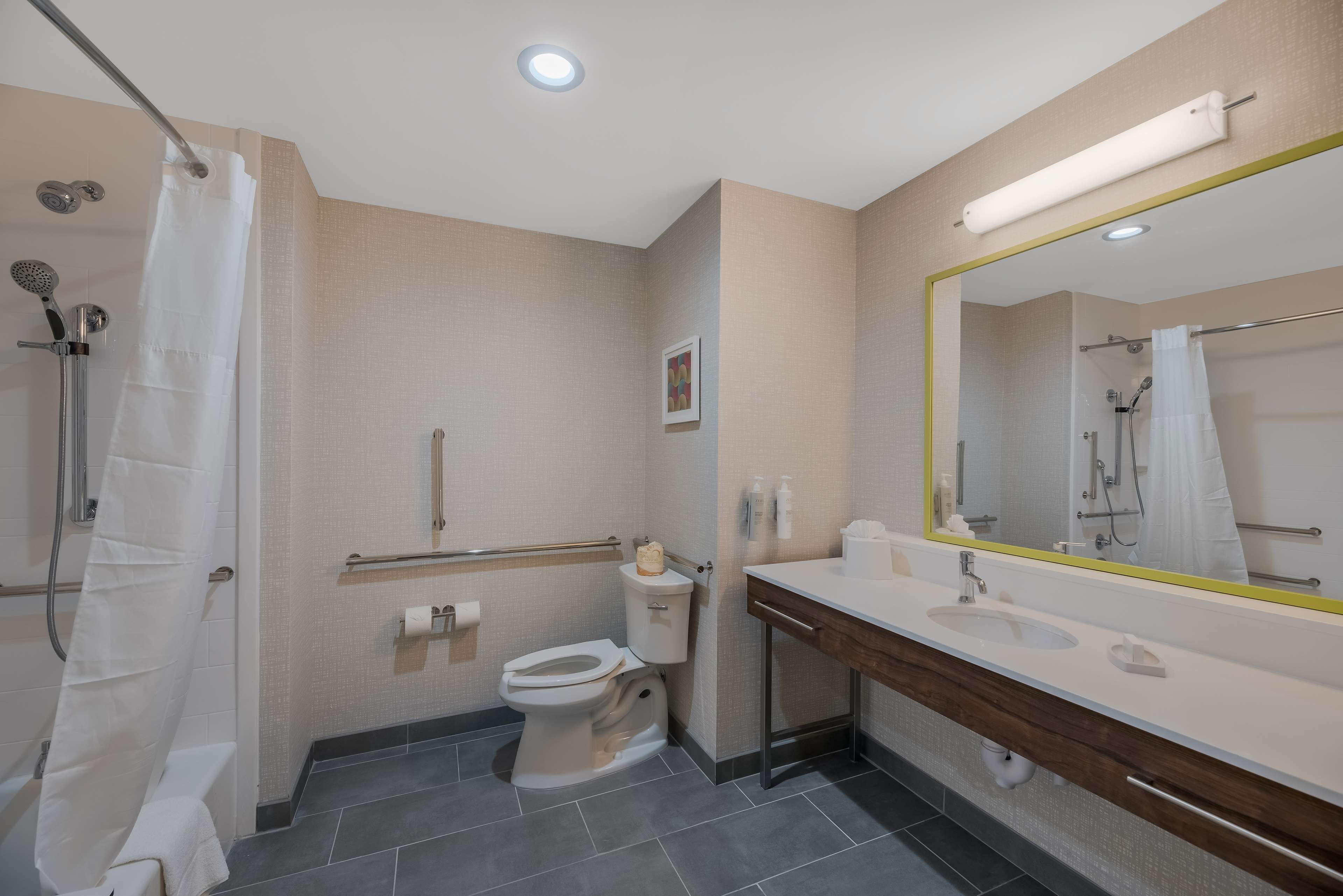 Un baño moderno con ducha, inodoro y lavamanos.