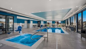 An indoor swimming pool area with two pools, a blue and white color scheme, and a seating area with chairs and tables. - Hampton Inn Williams (Williams)
