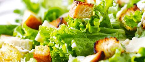 A close-up of a salad with croutons and lettuce.