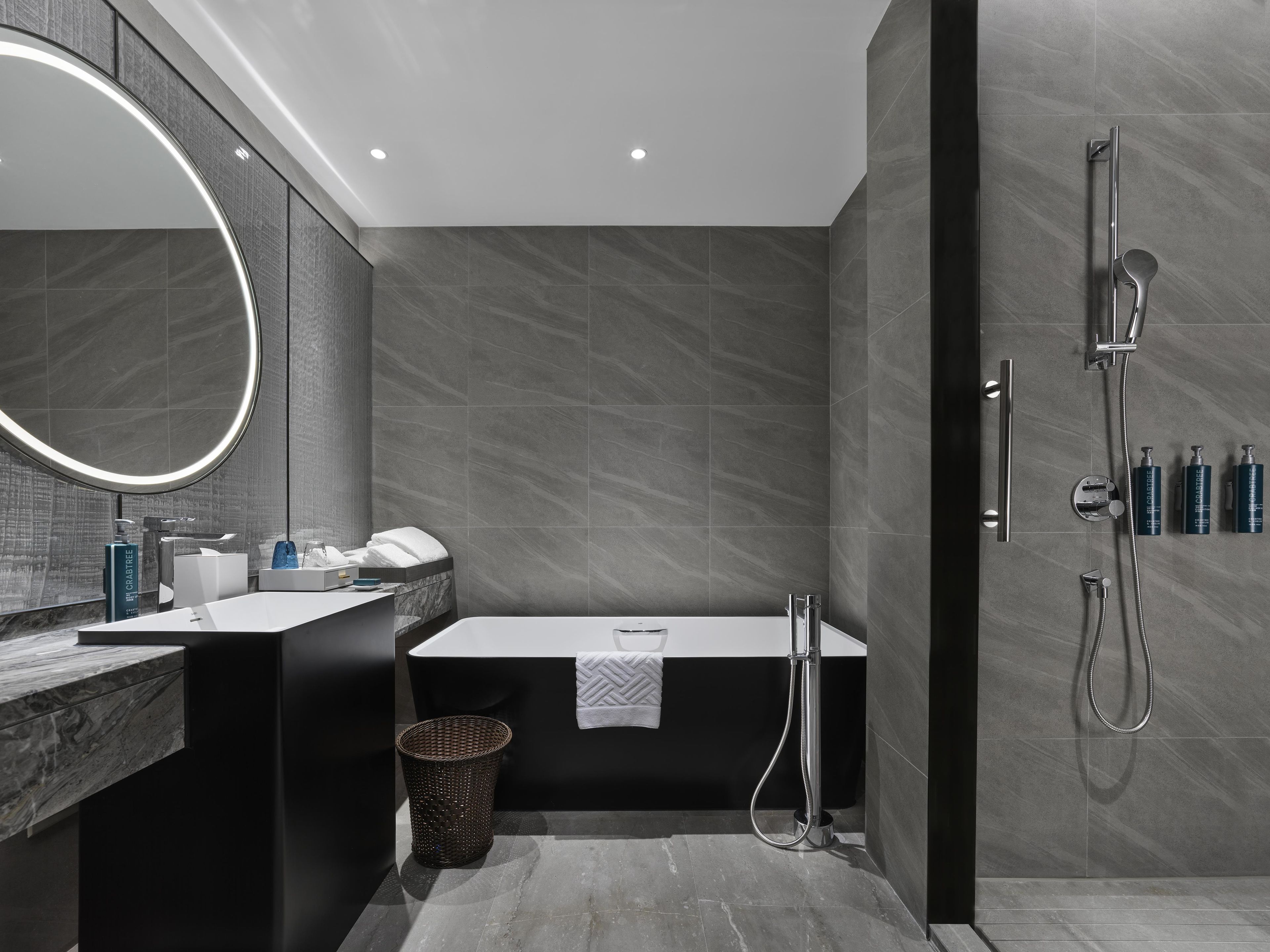 Une salle de bain moderne avec une baignoire, une douche et un meuble-lavabo avec un miroir.