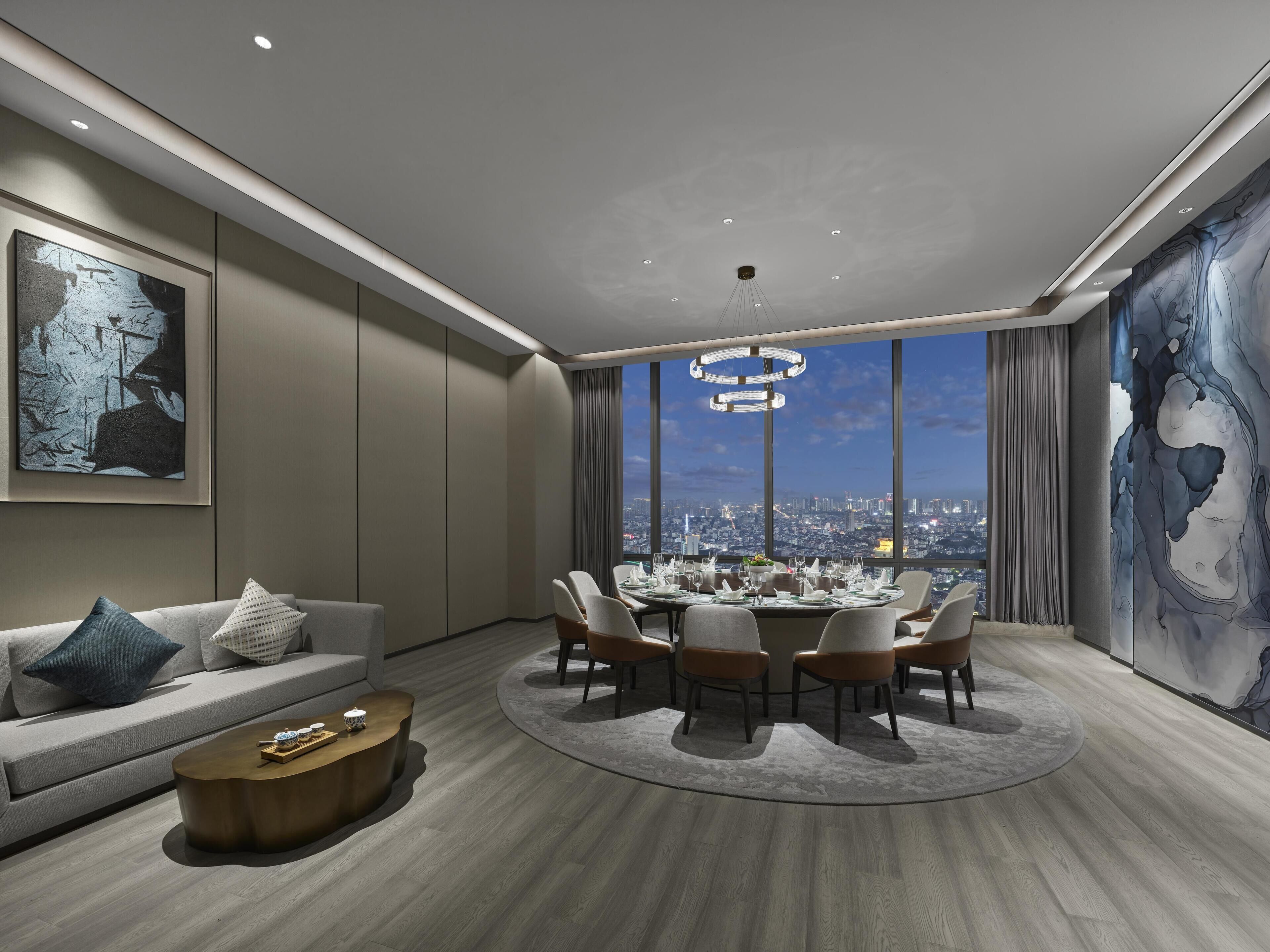 Un salon moderne avec un coin repas, de grandes fenêtres et une vue sur la ville.