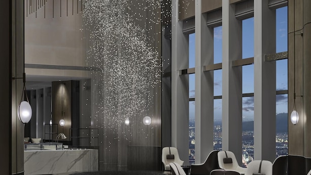 A modern lobby with a seating area, a reception desk, and a view of the cityscape through large windows. - Hilton Zhuji (Shaoxing)