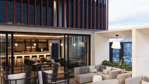 A modern outdoor living area with seating and a bar. - Hilton Monterrey Valle (Monterrey)