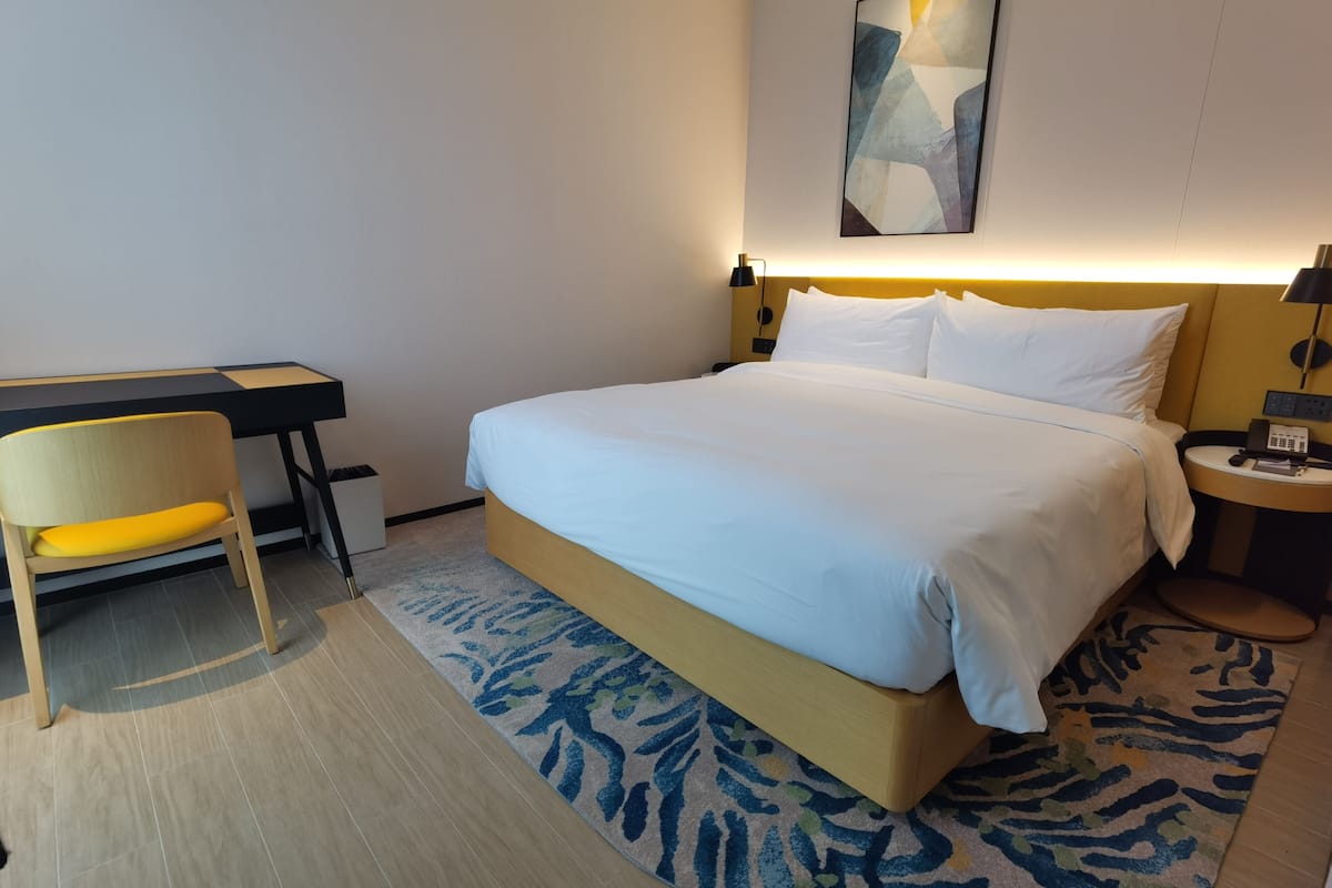 A hotel room with a bed, a desk, and a chair.