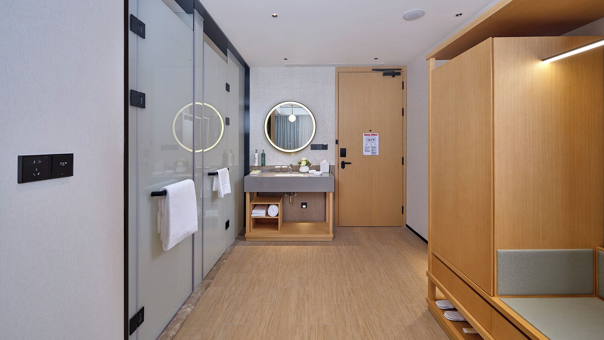 A modern bathroom with a glass shower enclosure, a vanity with a mirror, and a wooden cabinet.