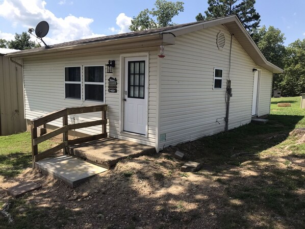 A small, single-story building with a front door, windows, and a satellite dish. - Clearwater Lake, cabin minutes from Bluff View Marina & boat dock (Piedmont)