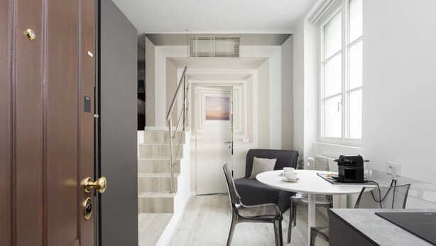 A modern kitchen with a dining area, a staircase, and a view of the outside. - Hostmate - Milano - S. Cecilia - Duomo  (Milano)