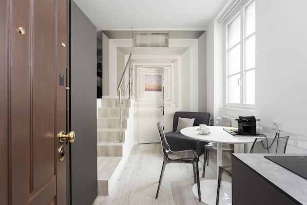 Une cuisine moderne avec un coin repas, un escalier et une vue sur l’extérieur.