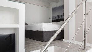 A modern bedroom with a bed, a glass shelf, and a staircase. - Hostmate - Milano - S. Cecilia - Duomo  (Milano)