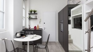 A modern kitchen with a dining area, a staircase, and a small living space. - Hostmate - Milano - S. Cecilia - Duomo  (Milano)