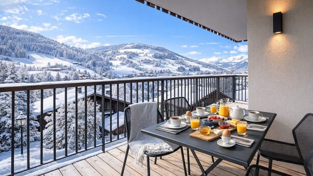 A balcony with a table set for breakfast, overlooking a snowy mountain landscape. - Stallion d15 MEGEVE (Megève)