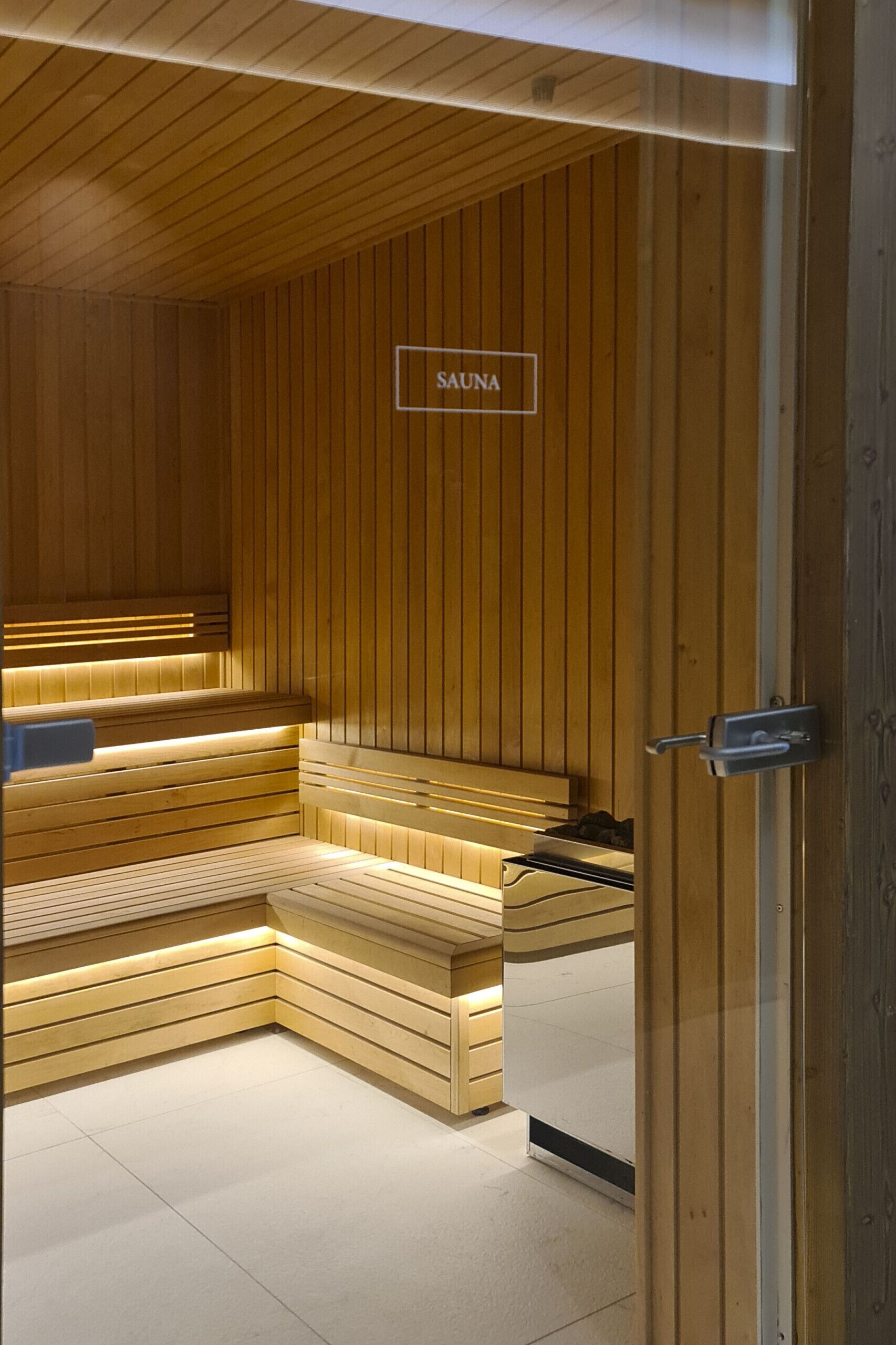 A sauna with wooden benches and a sign that reads "SAUNA".