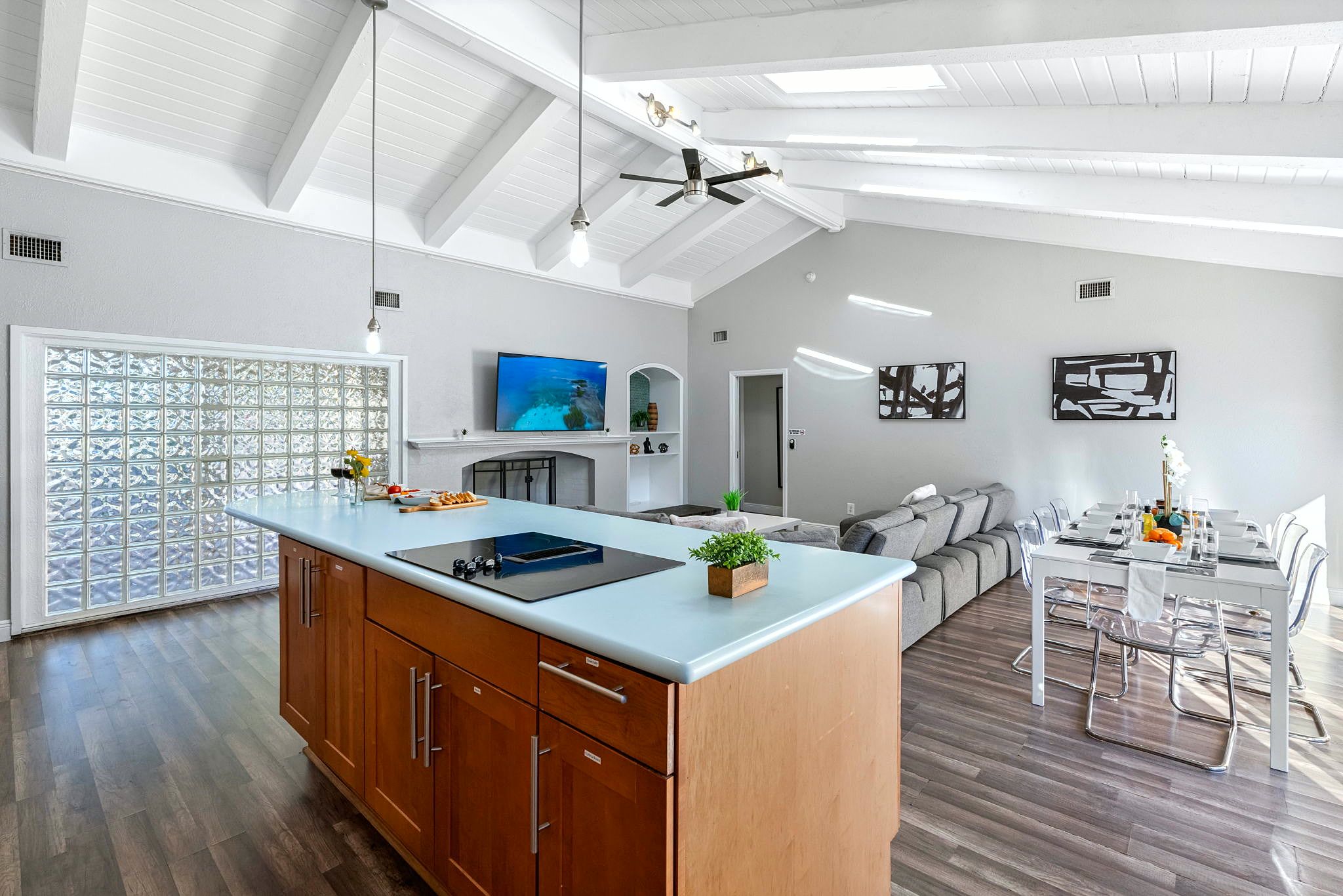 A modern kitchen with wooden cabinets, a built-in island, and a large window.