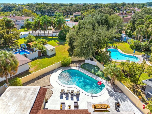A residential area with a swimming pool, lounge chairs, and a barbecue area.
