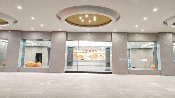 Un vestíbulo amplio con diseño moderno, que cuenta con una recepción central, grandes ventanales y una estética limpia y minimalista.
