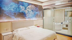 Habitación de hotel con una cama grande, mesita de noche, armario y baño con espejo y lavabo.