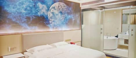 Ein Hotelzimmer mit einem großen Bett, einem Nachttisch, einem Kleiderschrank und einem Badezimmer mit Spiegel und Waschbecken.