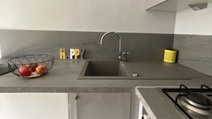 Eine moderne Küche mit Spüle, einer Obstschale und einem Schild mit der Aufschrift 'HAPPY'.