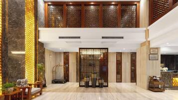 Un'ampia hall con reception, zona salotto e elementi decorativi.