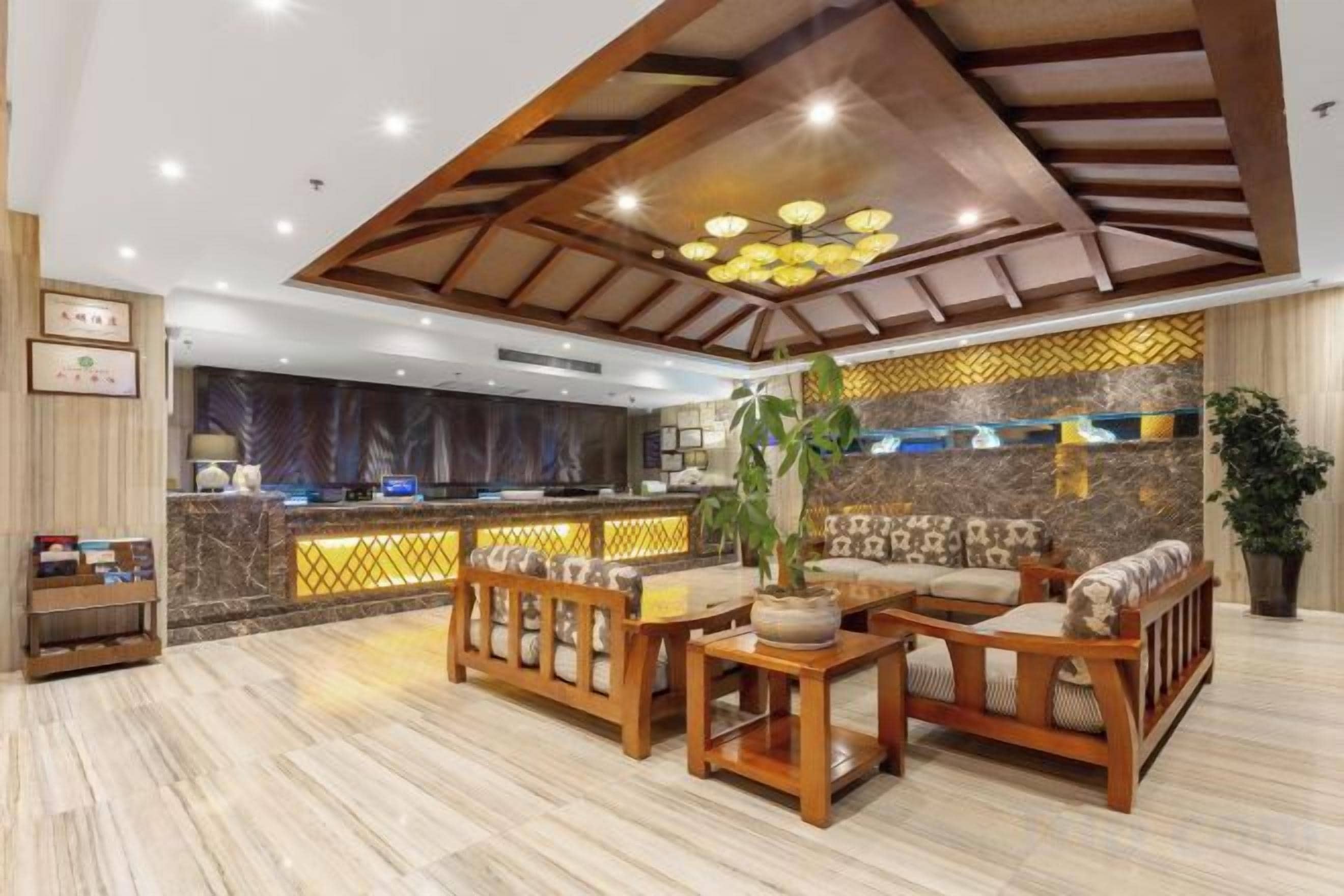 A lobby with a reception desk, seating area, and a decorative wall.
