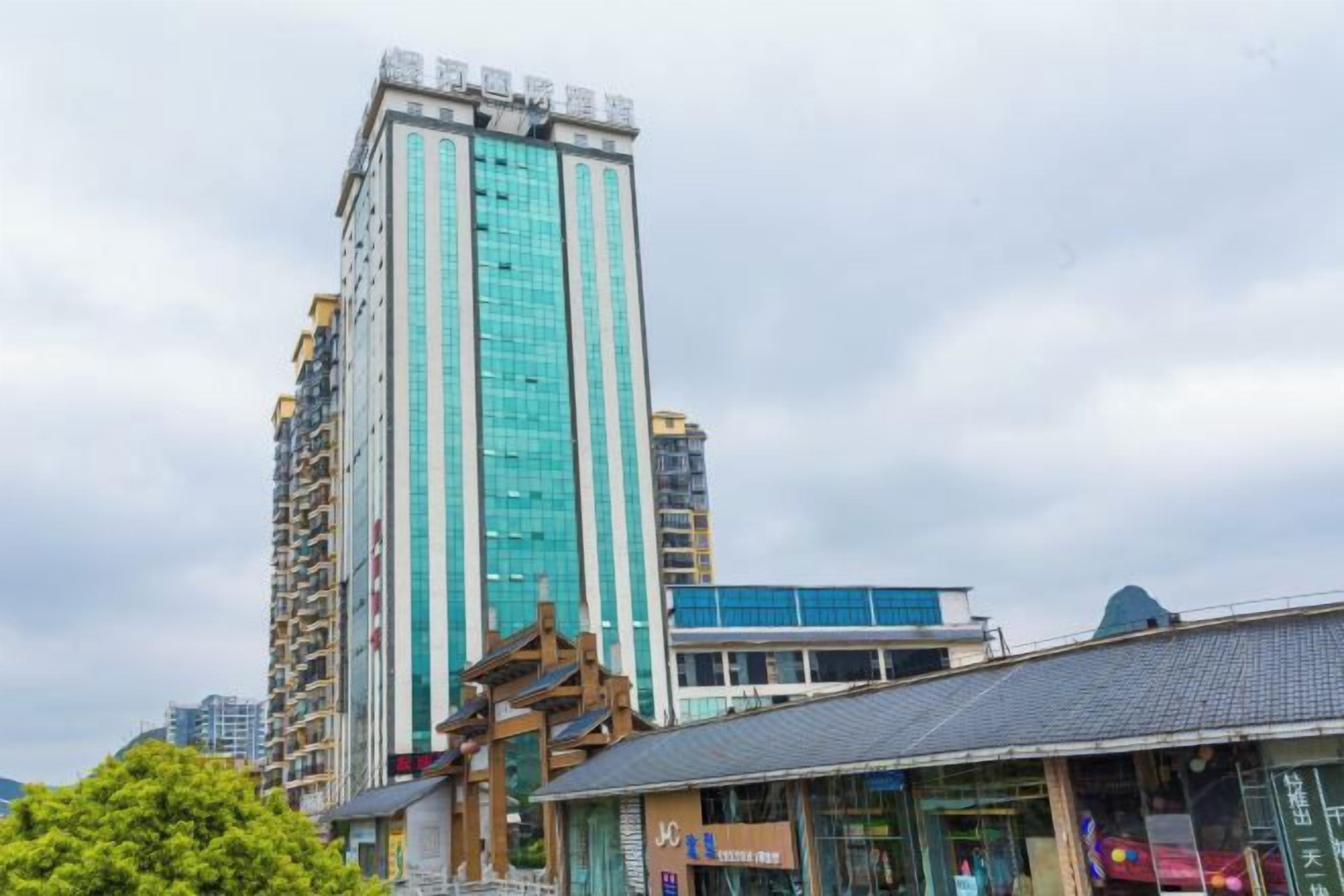 A high-rise building with a modern design, featuring a prominent glass facade and a structured, geometric shape.