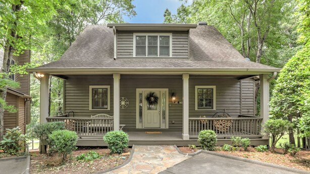 A two-story house with a front porch, a stone pathway leading to the entrance, and a small garden area. - Fairway to Seven - King Bed, Big-screen TVs & Golf Course Views (Jasper)