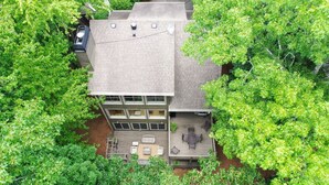 A multi-story building with a rooftop terrace, surrounded by dense green trees. - Fairway to Seven - King Bed, Big-screen TVs & Golf Course Views (Jasper)