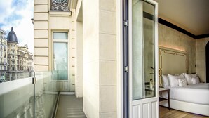 A modern hotel room with a balcony, a bed, and a view of historic buildings. - Hotel Montera Madrid, Curio Collection By Hilton (Madrid)