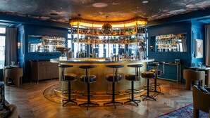 A bar with a central round table, multiple stools, and a ceiling with a galaxy design. - Hotel Montera Madrid, Curio Collection By Hilton (Madrid)
