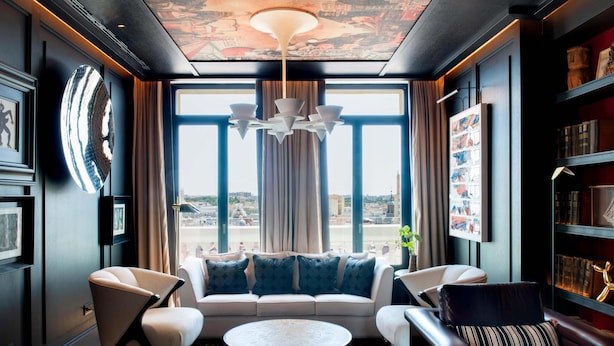 A modern living room with a sofa, chairs, a coffee table, and a large window with curtains. - Hotel Montera Madrid, Curio Collection By Hilton (Madrid)