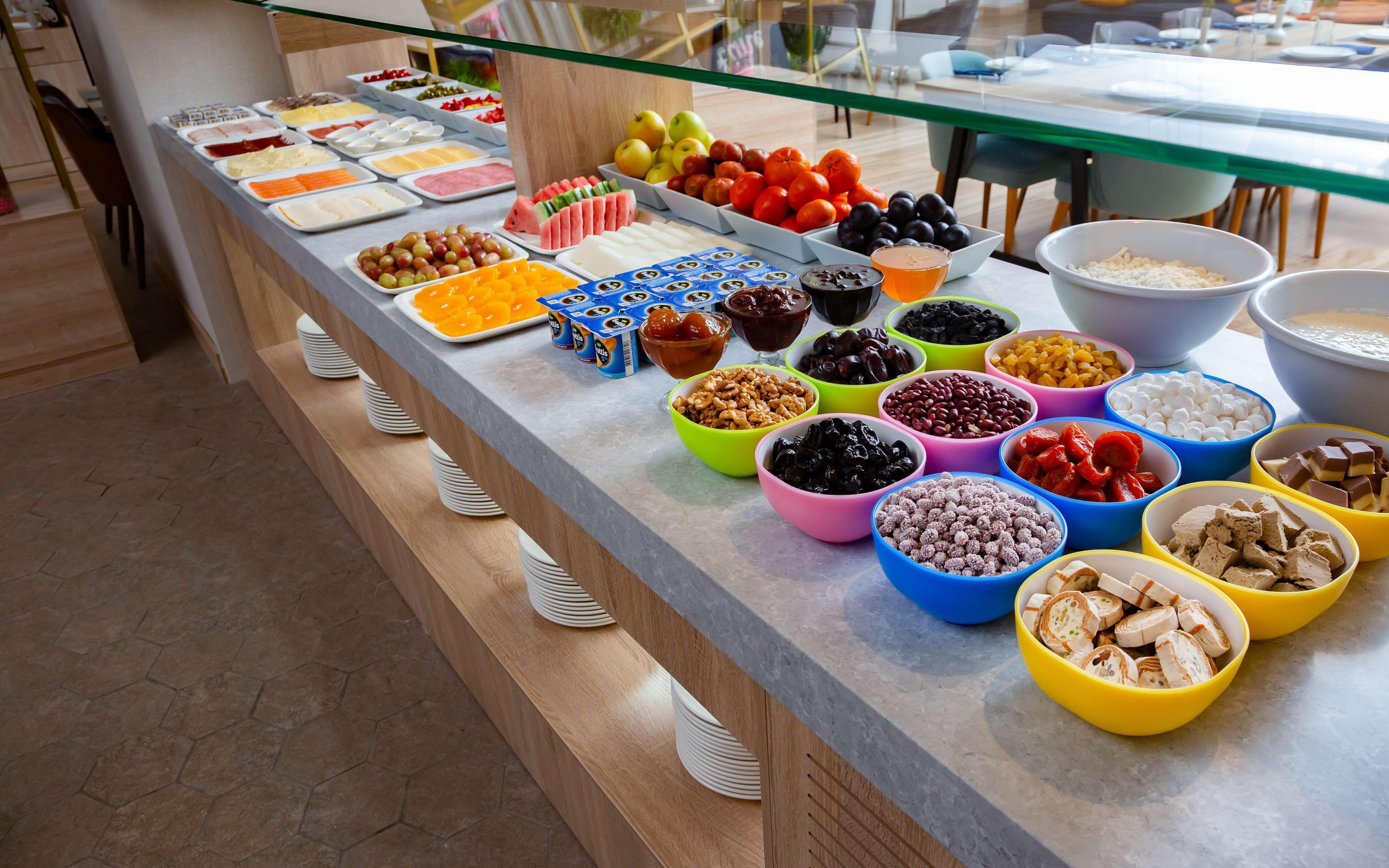 Un bufé con diferentes alimentos y bebidas dispuestas en un mostrador.