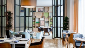 Un comedor moderno con techos altos, ventanas amplias y una variedad de opciones de asientos.