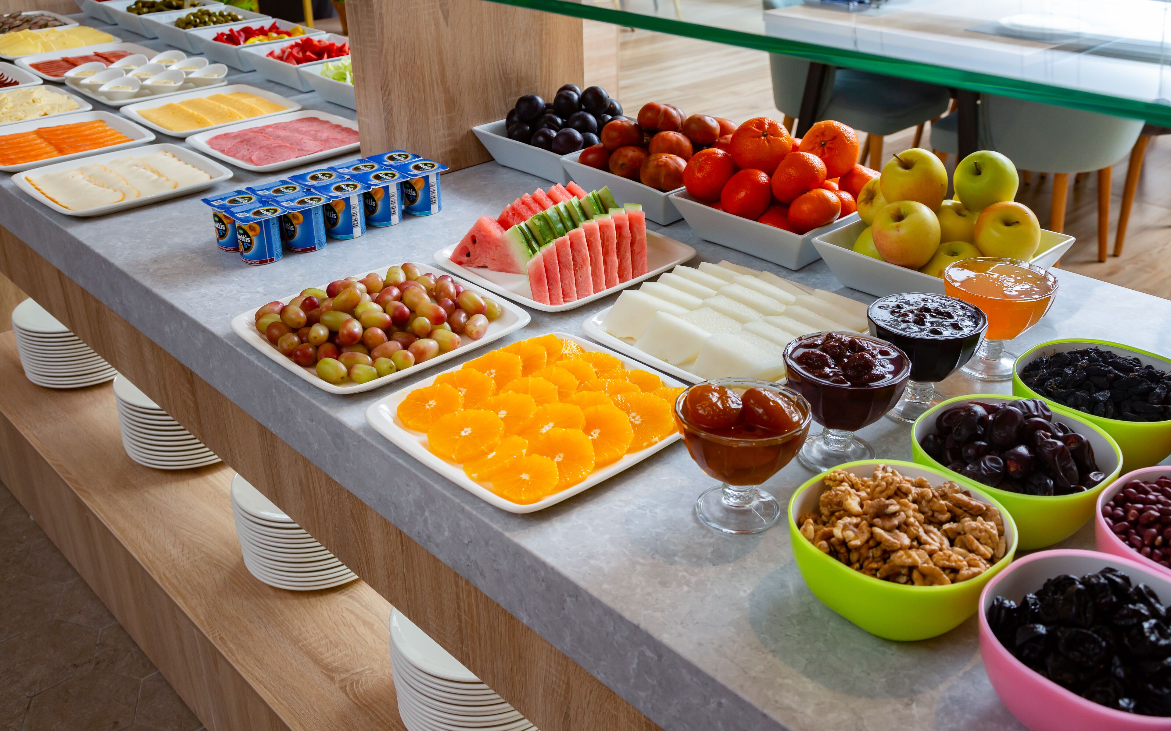 A buffet with various food items including fruits, cheeses, and nuts.