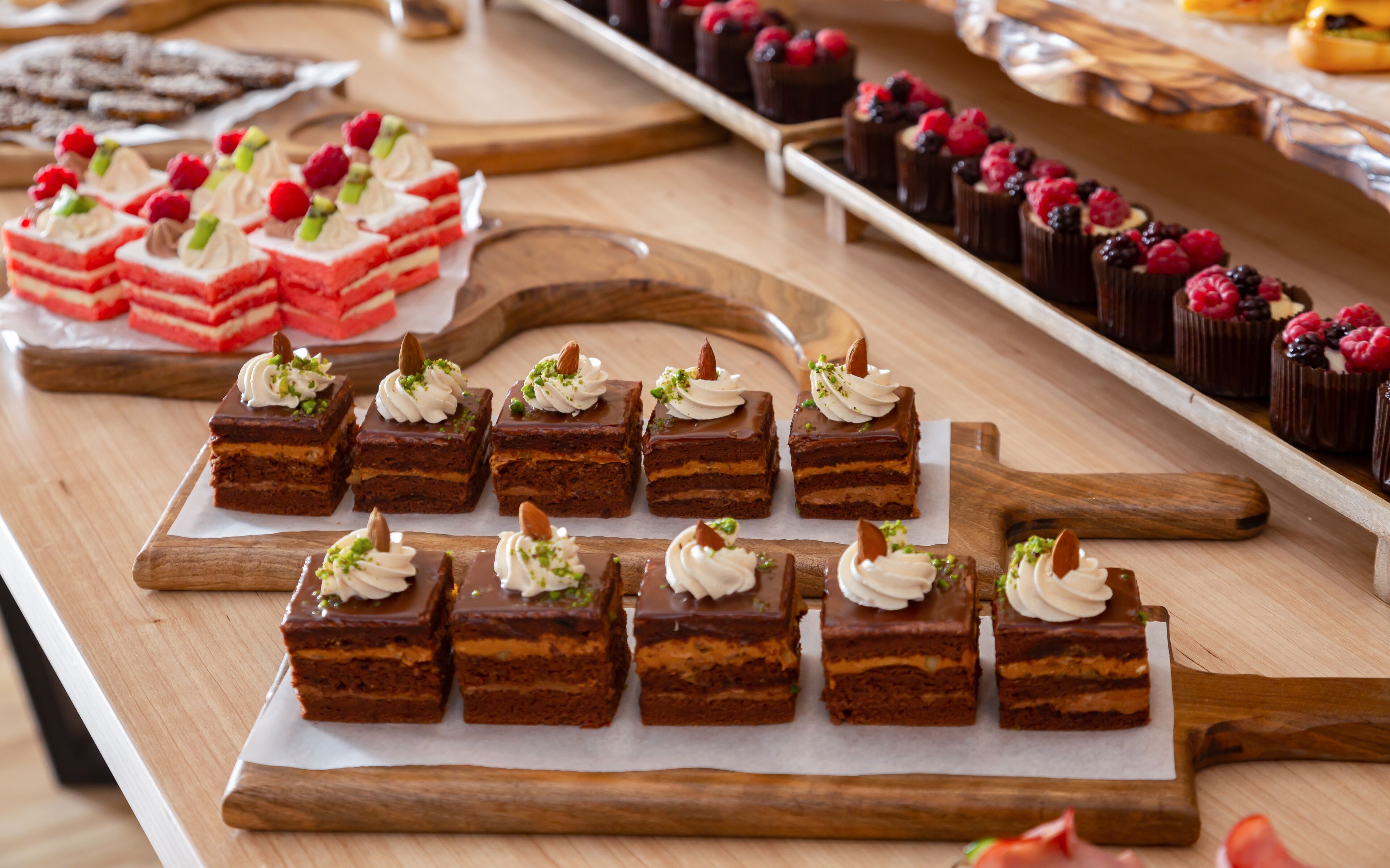 Verschiedene Desserts auf Holzservierbrettern.