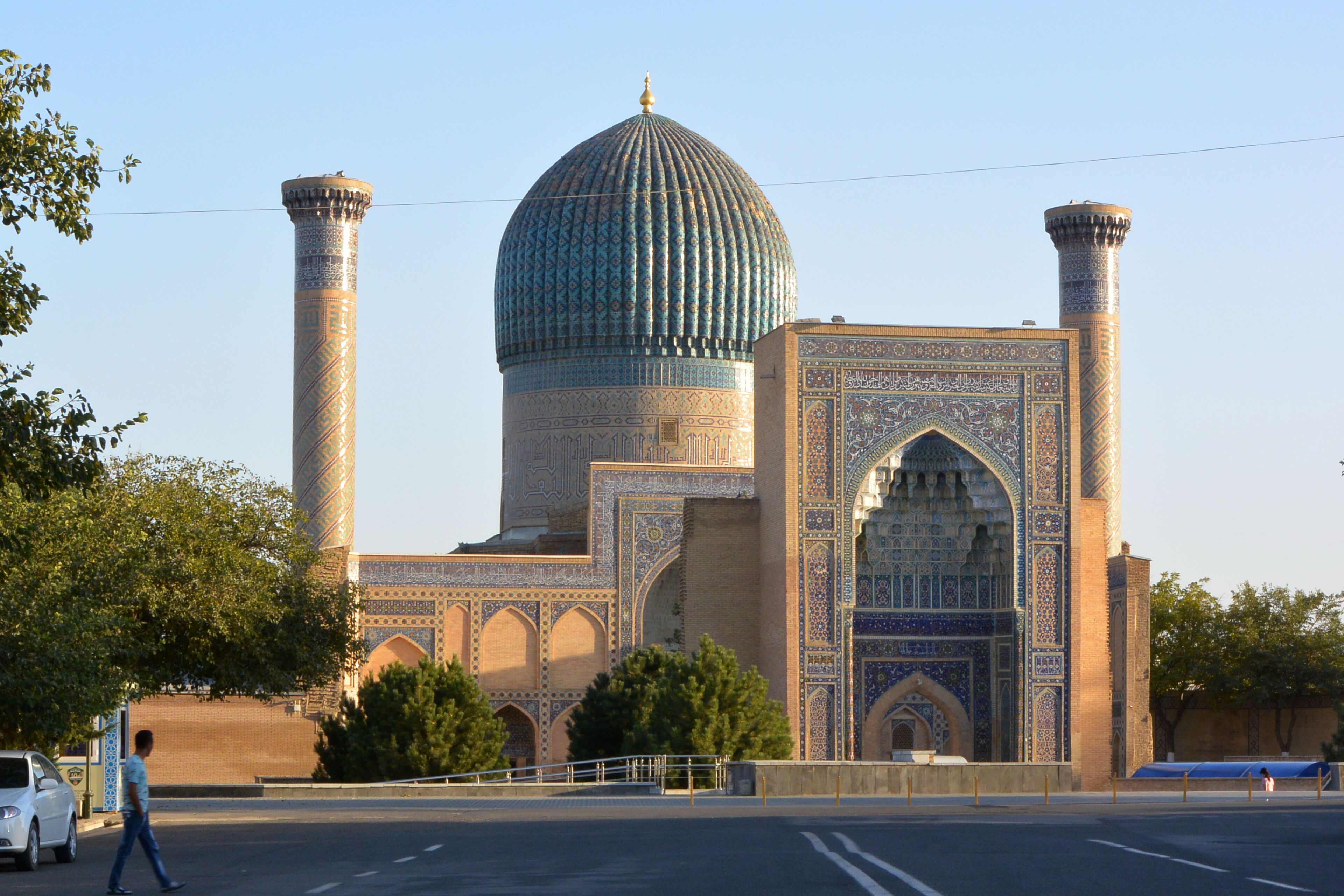 A large, ornate building with a prominent dome and tall minarets, featuring intricate tile work and arched doorways.