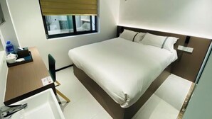 A hotel room with a bed, a desk with a chair, a window with blinds, and an air conditioning unit. - Fuzhou Xiao Boutique Hotel (Sanfang Qixiang Provincial Hospital) (Fuzhou)