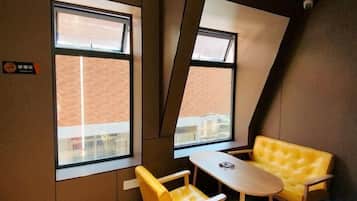 Une pièce avec un lit, une fenêtre et une petite table.