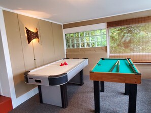 A pool table with a white felt surface and a pool cue rack.