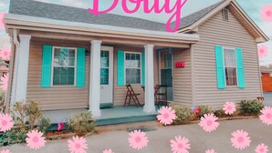 Et toetagers hus med en veranda, nummereret 115, og et skilt med teksten "the Dolly".