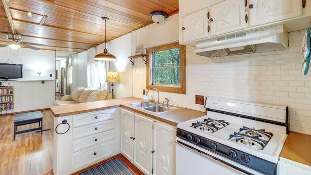 A kitchen with white cabinets, a gas stove, and a wooden ceiling. - Edgemont Home w/ Deck ~ 9 Mi to Greers Ferry Lake! (Edgemont)
